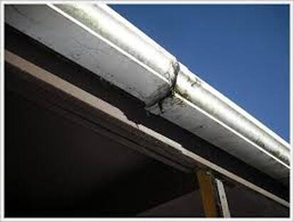 Broken, cracked, and damaged gutters in need of replacing on the roof of a house.
